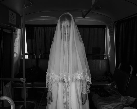 Republic of Chechnya, Russia, 03/2013. Rada, 14, trying on a wedding dress designed by her sister inside a bus during a rehearsal for a movie on the Chechen deportation. As in many other Muslim countries, child brides were very common in Chechnya. Although President Kadyrov strongly promotes a merger of Chechen tradition and Islamic law, the Russian federal government recently forced him to publicly condemn the practice of child marriage, which is illegal throughout the Russian Federation. Shatoy. © Davide Monteleone /VII for Carmignac Gestion Photojournalism Award