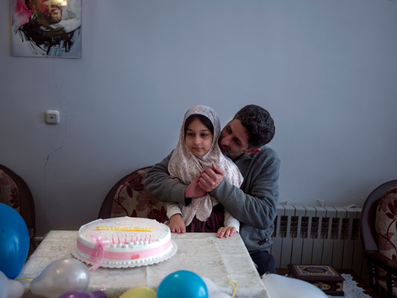 Ali, a war veteran, holding his daughter Hadis, on her 8th birthday party. He fought on the fronts of the Iran-Iraq war for seven years, joining as a volunteer when he was 16. “ My body has returned home,” he says, “but my spirit stayed behind.”  © Newsha Tavakolian