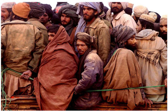 Taliban prisoners squeezed onto a truck in the desert, North Afghanistan, November 2001 © James Hill