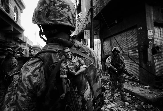 Anja Niedringhaus: A US Marine of the 1st Division carries a GI Joe mascot as a good luck
charm in his backpack while his unit pushes further into the western part of the city,
Fallujah, Iraq, November 2004 
© picture alliance / AP Images