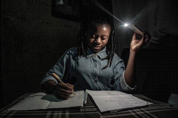 Goma, Democratic Republic of Congo, April 27-28, 2020. With schools closed during Congo’s period of confinement, and the city implementing regular power cuts, my 13-year-old sister Marie studies at home by the light of a mobile phone. © Arlette Bashizi for Fondation Carmignac