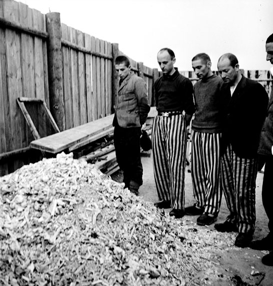 Released prisoners in striped prison dress beside a heap of bones from bodies burned in the crematorium Buchenwald, Germany, 1945© Lee Miller Archives, England 2020All rights reserved. leemiller.co.uk