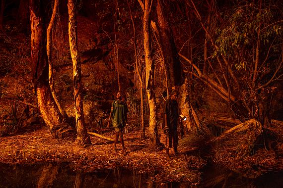 World Press Photo Story of the YearMatthew Abbott for National Geographic/Panos PicturesStacey Lee (11, left) sets the bark of trees alight to produce a natural light source to help hunt for file snakes(Acrochordus arafurae), in Djulkar, Arnhem Land, Australia, on 22 July 2021. 