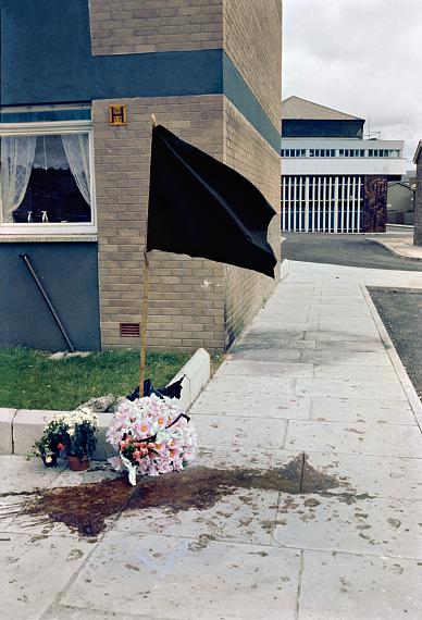 Street memorial on Lecky Road, Derry city, 1971, marking the site where Desmond
Beattie (19 years old) was shot and killed on 8 July 1971 by the British Army. 
Seamus Cusack (28 years old) was shot dead near this spot about twelve hours later. 
These men were the first people shot dead by the British Army in Derry.
© Estate of Akihiko Okamura