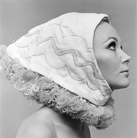 Closeup of a woman in black and white, wearing a headpiece that covers her hair.
Mode voor Avenue, 1966
© Paul Huf / MAI.