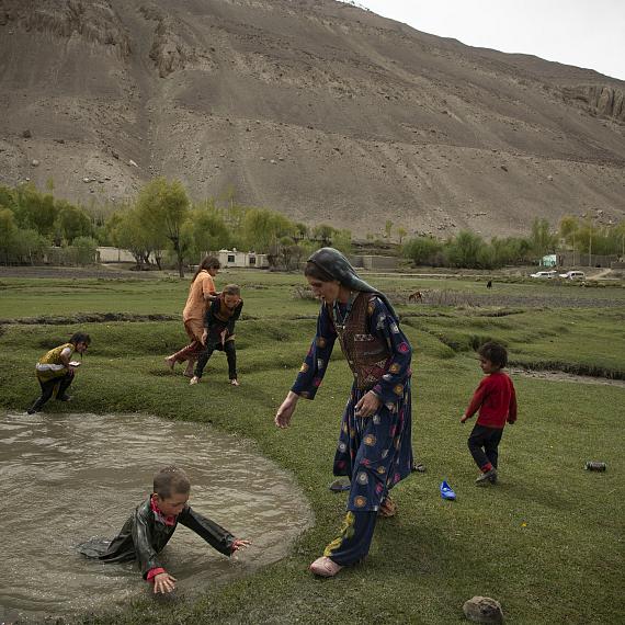 Yamit District, Badakhshan, Afghanistan, May 10, 2024. Kheshroo's daughter and her cousin, both grade 11 students who were put out of school, committed suicide a year before by throwing themselves in the water. The family plays in puddles of water, among troops of yaks, horses and goats, in front of the Wakhan mountains, Wakhan, a region that had never been controlled by the Taliban before 2021. 
© Kiana Hayeri for Fondation Carmignac