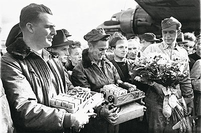 Nach der Aufhebung der Blockade am 12. Mai 1949 bedanken sich die Berliner beim Abschied der ersten Piloten mit Blumen und Süßigkeiten für deren Einsatz. © Henry Ries / The New York Times / DHM