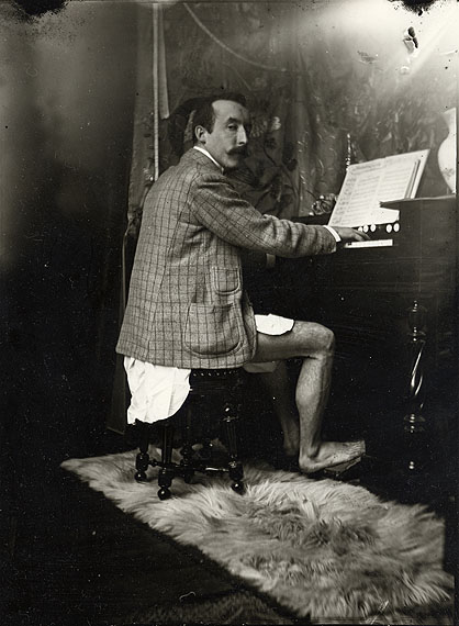 Alphonse Mucha, Paul Gauguin am Harmonium in Muchas Atelier , Paris, um 1893/94Silbergelatine, 24 x 18 cmMucha Foundation, Prag