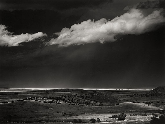 Ansel AdamsSTORM OVER THE GREAT PLAINS FROM CIMARRON, NEW MEXICO. 1960Gelatin silver print, c. 1975. 37,3 x 49,2 cm. Laid down on original cardboard, thereupon lower right signed in pencil. On the reverse of the cardboard photographer's stamp, therein dated and inscribed in black felt-tip pen. Courtesy Villa Grisebach Auktionen