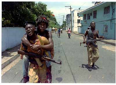 Jugendliche Soldaten tragen einen im Straßenkampf Verwundeten zum Krankenhaus. Monrovia, Liberia 1996
