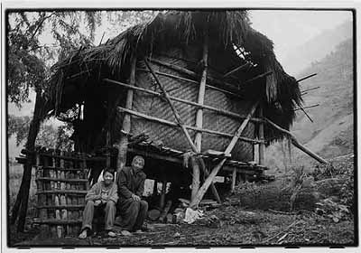 Yunnan, 1998 ©Zhang Xinmin A boy sits with his grandfather next to a traditionally constructed rural dwelling. Children are frequently left with grandparents while their parents earn a living in the cities.