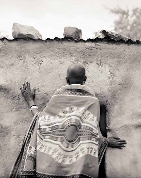 Behind, Partimbo, near Kittel, Manyara Region, Tanzania, 2018. Maseriani Lenyirai, entering her home. 
Aus der Serie "From Where Loss Comes", Platinum-palladium-Abzug auf Revere Platinum Papier 
© Pradip Malde