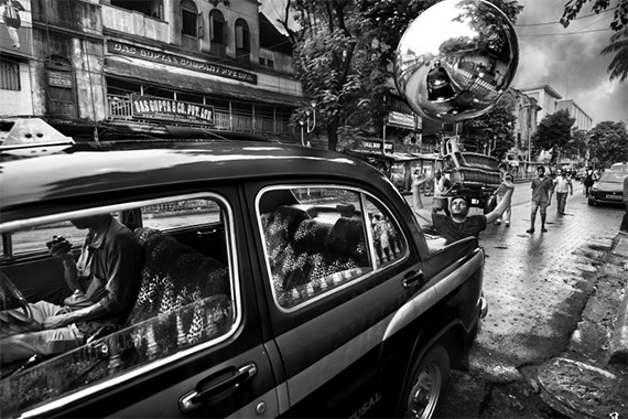 Max Vadukul, Taxi Driver Lunch vs Zero Emission Man, from the series “The Witness”, College Street,                                                        Kolkata (India), 2019 © Max Vadukul